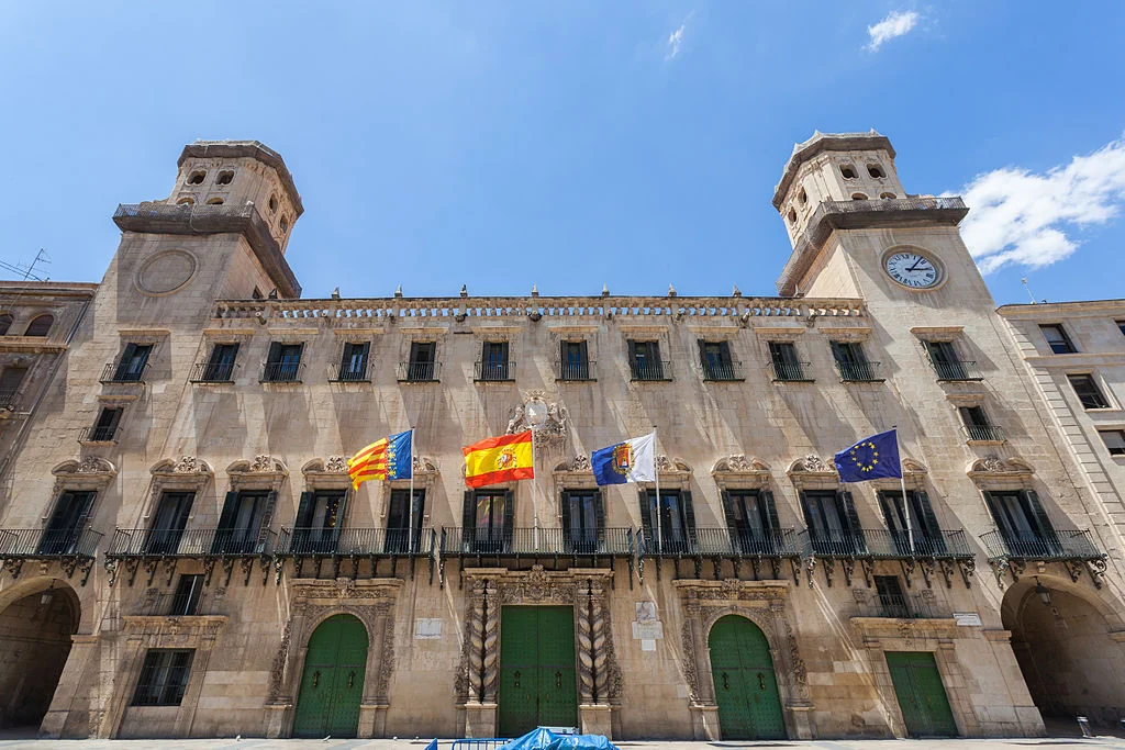 alicante town hall building with spanish and eu flags under blue sky