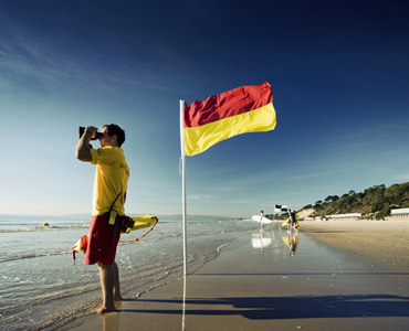 Spanish lifeguard at beach with warning flag