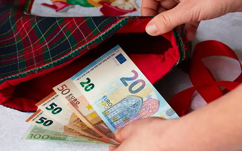 Euro banknotes and coins spread out on a surface, illustrating currency and money-saving tips for living in Spain