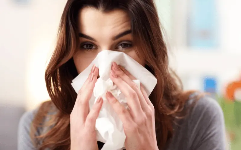 Women holding tissue to mouth and nose