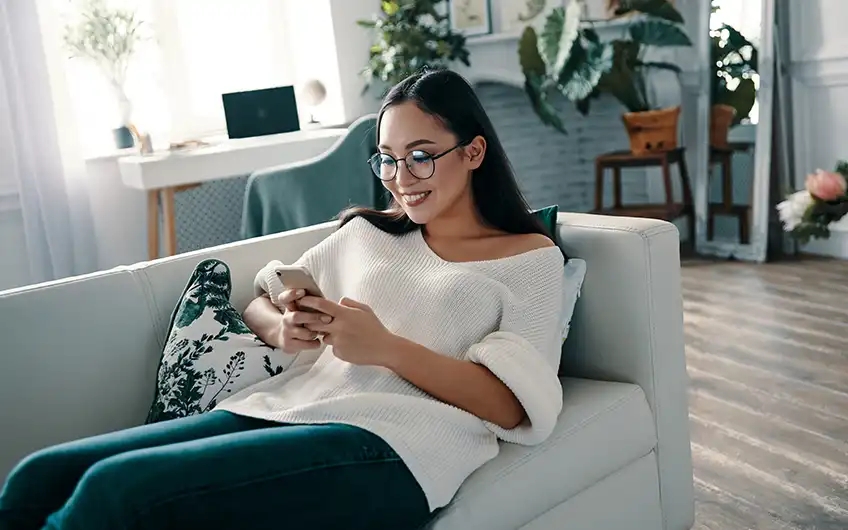 Woman having a video consultation with a Sanitas doctor on her phone at home in Spain