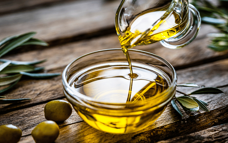 pouring olive oil in to a glass bowl