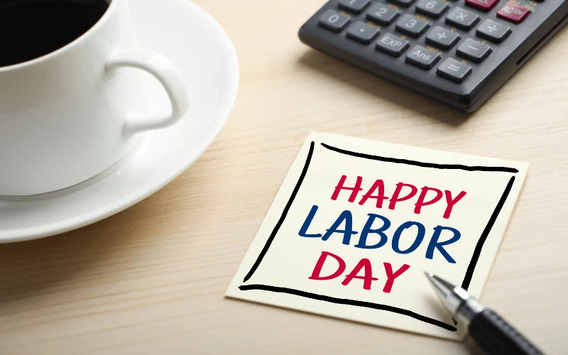 Happy Labor Day note on desk with coffee cup and calculator