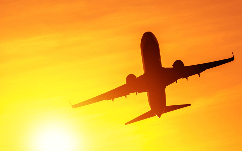 Plane taking off with sun in background