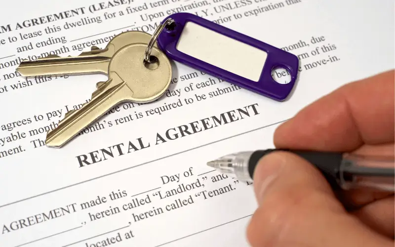 Person signing a rental agreement with keys