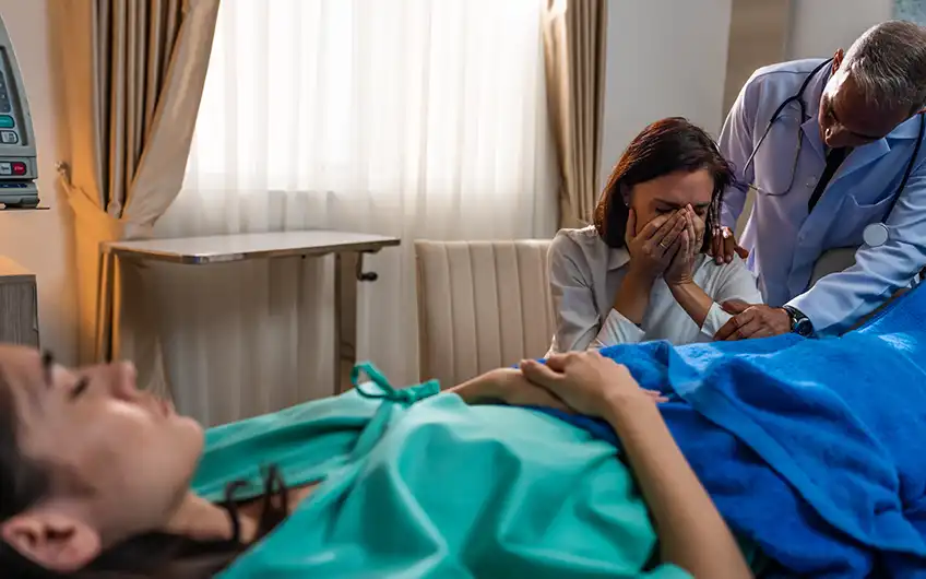 A woman being supported by her partner in a hospital consulting room in Spain