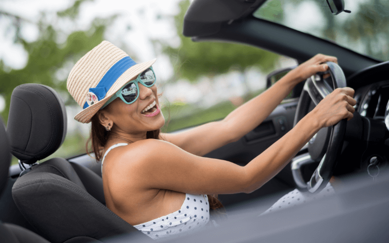Woman driving with hat and sunglasses on