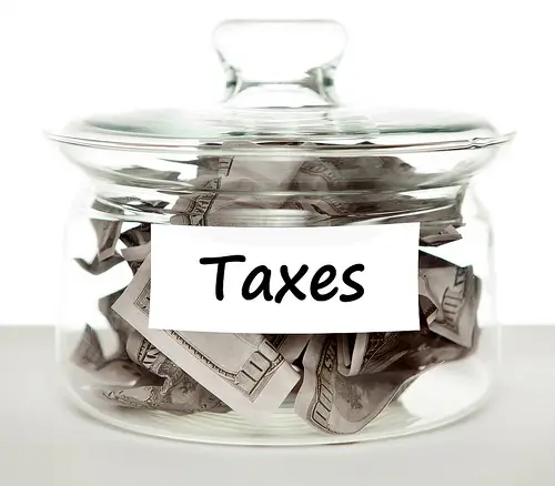 Jar of money with taxes on label