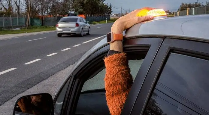 V16 emergency beacon light being placed on top of car